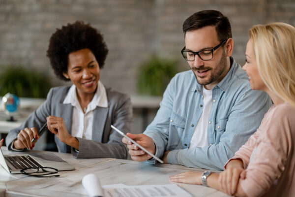 husband and wife meeting with bank manager, sitting at a table.