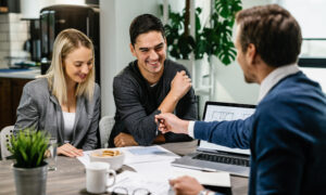 Couple sitting at a table having a meeting with a man wearing a suit