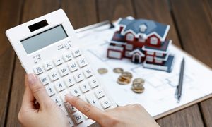 female-hand-operating-calculator-front-villa-house-model-scaled.jpg